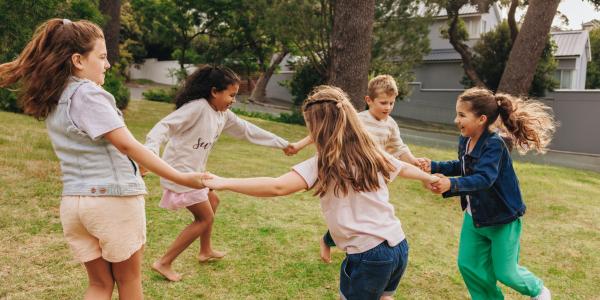 five children holding hands and playing in a circle