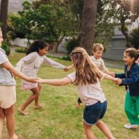 five children holding hands and playing in a circle