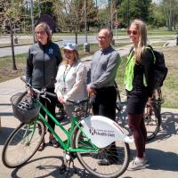 representatives from TBDHU, City of Thunder Bay and Confederation College pose in front of a bicycle